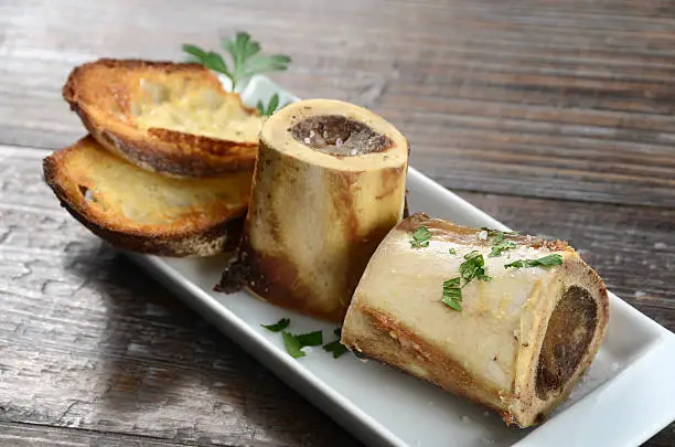 A classic bistro appetizer - roasted beef marrow bones sprinkled with sea salt and served with toasted crusty bread.