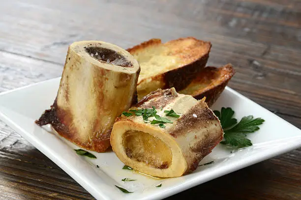 A classic bistro appetizer - roasted beef marrow bones sprinkled with sea salt and served with toasted crusty bread.