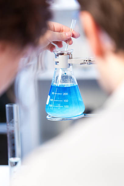 istock Technicians Stirring Liquid in Flask, Observing Chemistry Laboratory Experiment Vertical 187581770