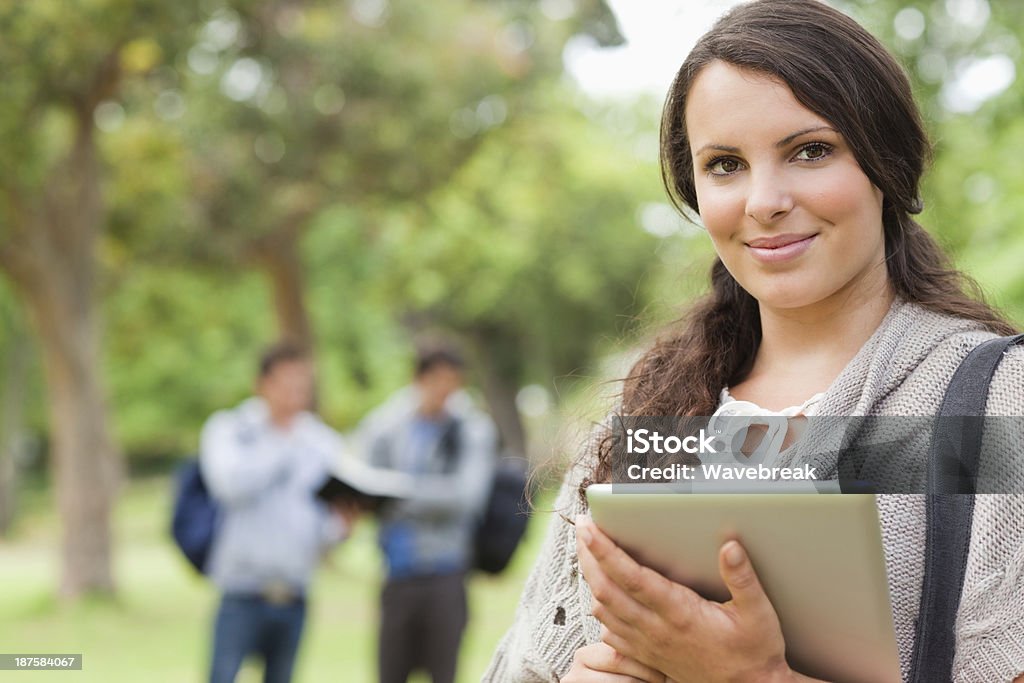 Ritratto di una graziosa brunette utilizzando touch pad - Foto stock royalty-free di 18-19 anni