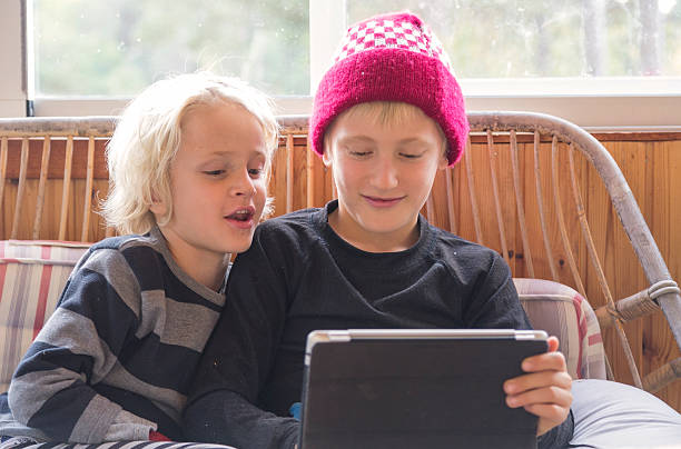 istock Little brothers concentrating on the screen where something interesting happens. 187584468
