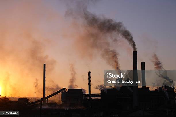 Backlit Paper Mill Factory Sunset With Dark Smoke Rising Upwards Stock Photo - Download Image Now