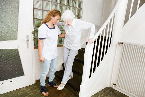 istock old senior woman climbing stairs with assitance 187584994