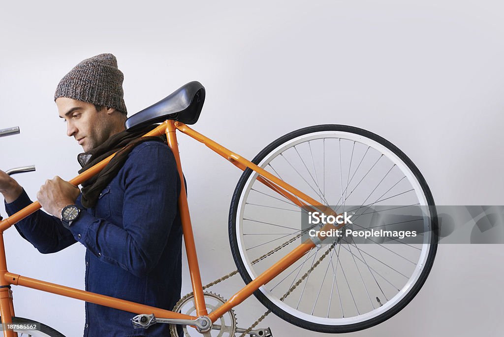 On the move with feet and wheels Shot of a hop young man carrying a retro bike Bicycle Stock Photo