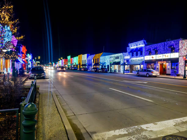 ミシガン州ロチェスターのダウンタウンにあるメインストリートのロチェスターロードにあるビッグで明るいライトショーの眺めと、ホリデークリスマスライトで飾られた店舗や企業 - street name sign small town america street street light ストックフォトと画像