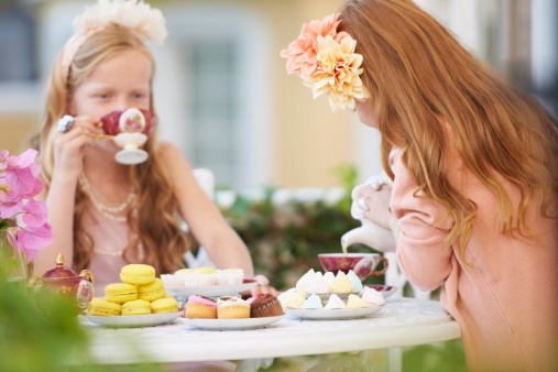 Two young girls having a tea party in the backyard