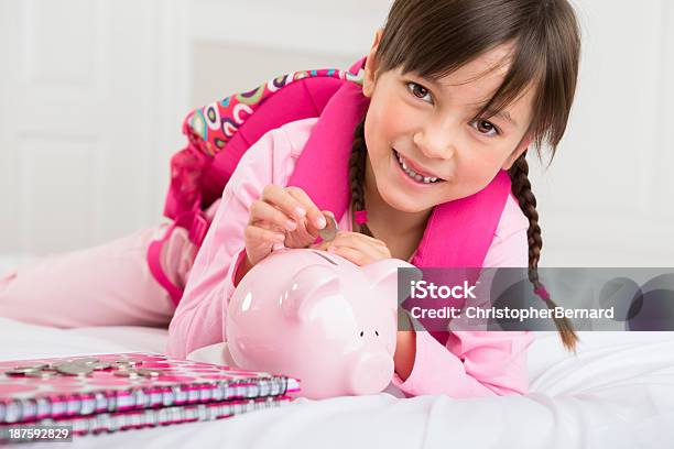 Chica Poner Dinero En La Alcancía Foto de stock y más banco de imágenes de Niñas - Niñas, 8-9 años, Acostado