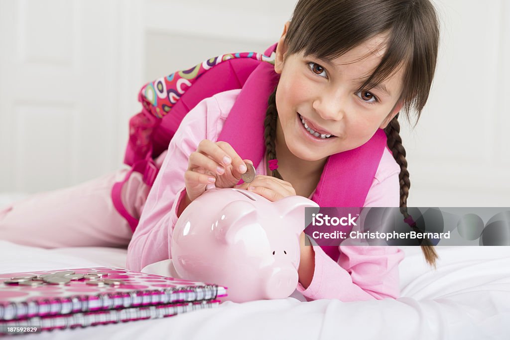 Jovem garota colocando dinheiro em seu piggy bank - Foto de stock de Menina royalty-free