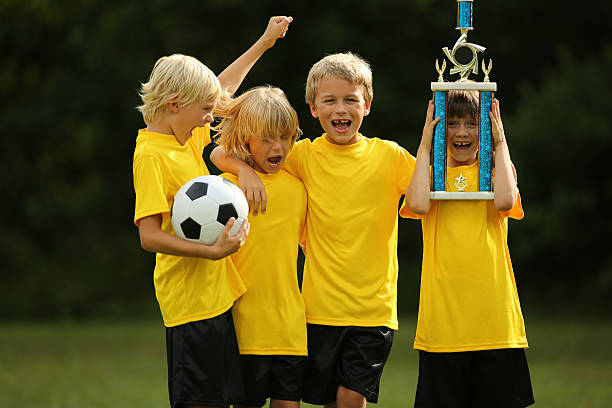 istock Excited Boys With Soccer Trophy Celebrating Success 187593073