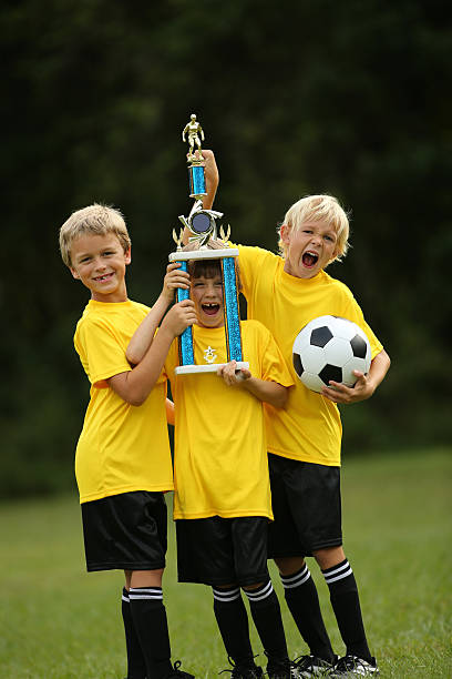 istock Soccer Players Cheering And Holding Victory Cup 187593571