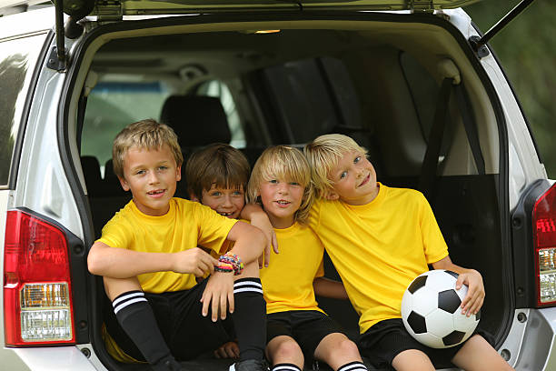 istock Young Soccer Players Sitting In Open Car Trunk 187593630