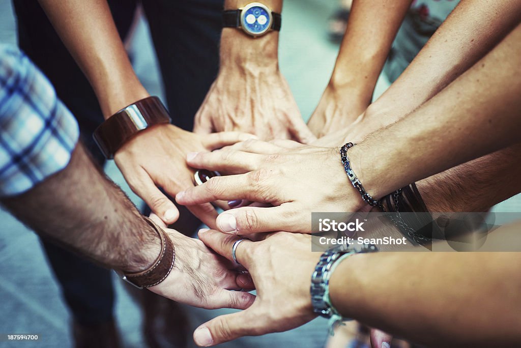 Young Adult Team Joining Hands Young adult team joining hands Bridging The Gap Stock Photo