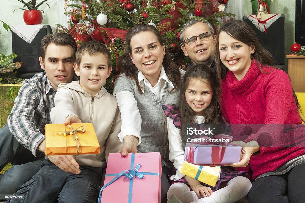 Christmas in family Family Opening Christmas Gifts At Home In Front Of Christmas Tree 10-11 Years Stock Photo