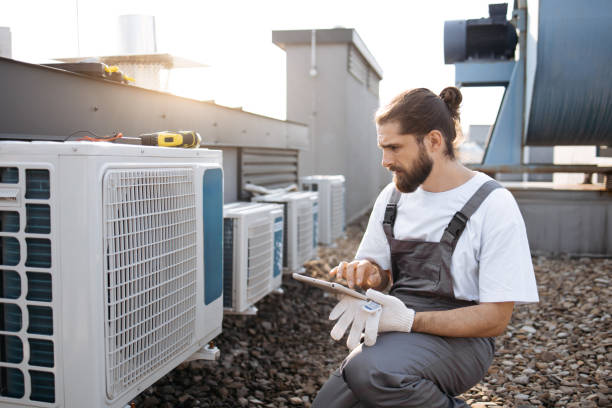 Man master holding tablet and inspecting conditioner outdoor