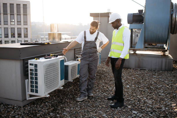 istock Repairmen standing and looking at conditioner on rooftop 1875959736