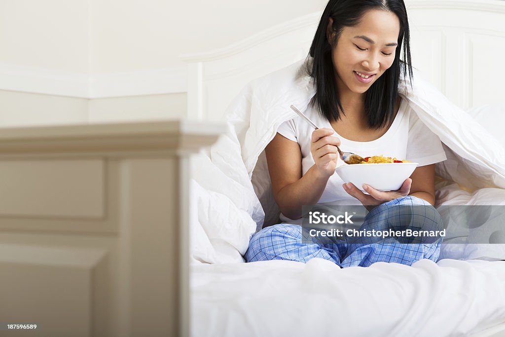 Mulher asiática a comer o pequeno-almoço na cama - Royalty-free 30-34 Anos Foto de stock