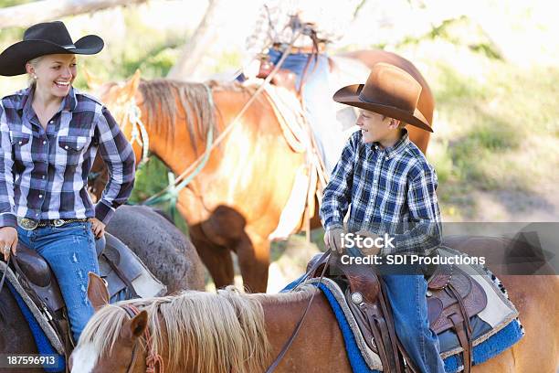 Femmina Rancher Equitazione Cavallo Con Il Suo Giovane Figlio - Fotografie stock e altre immagini di Adulto