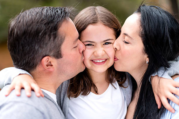 istock Parents kissing their daughter 187597403