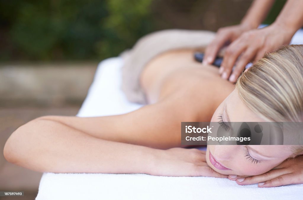 Dreaming while being pampered A young woman enjoying a relaxing massage Blond Hair Stock Photo