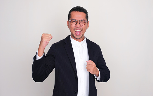 Asian businessman clenched fist showing optimist expression