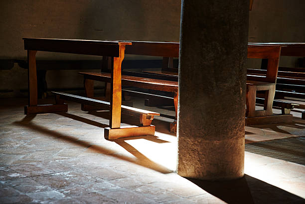 Detail of a warm sun light into an old and simple italian church