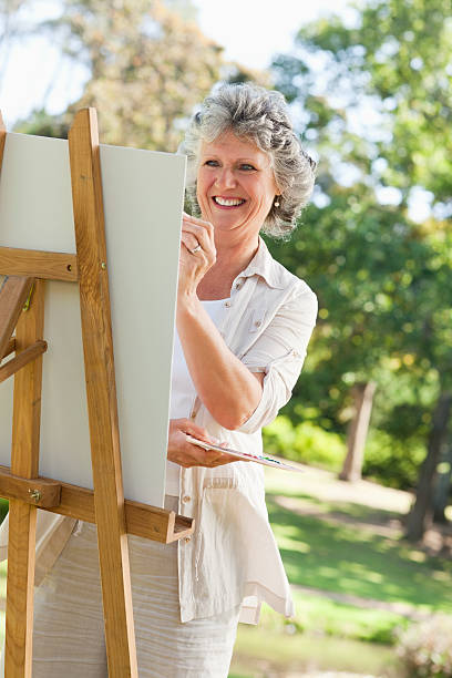 istock Woman is smiling while painting picture 187612526