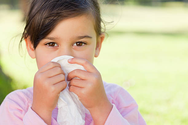 istock Ggirl outdoors blowing her nose into a tissue 187612714