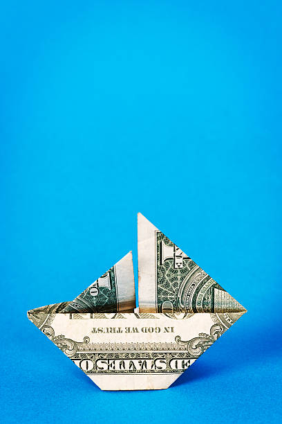 istock Little sailing boat folded origami-style from dollar bill 187613750