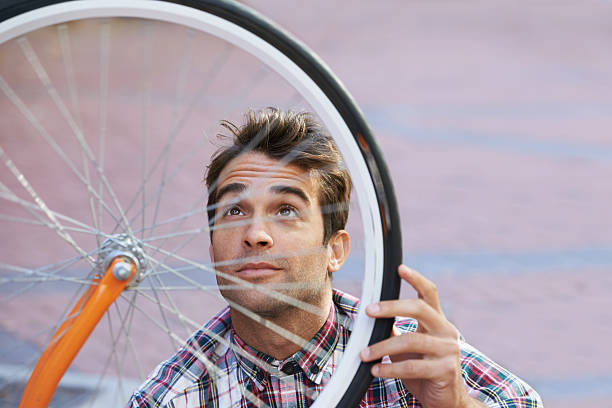 A young man with a bicycle in the city