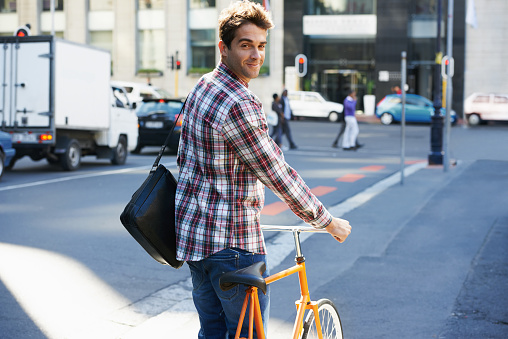 A young man with his bicycle in the city