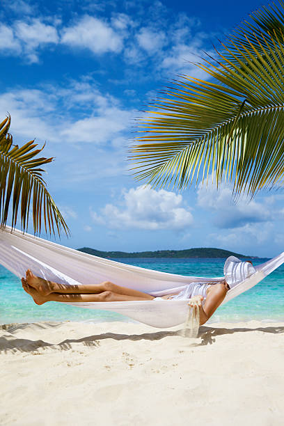 istock woman playing with the sand while relaxing in a hammock 187617779