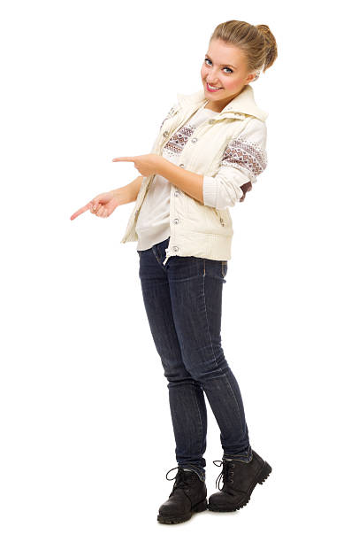 Full length / side view / profile view / one person of 30-39 years old adult beautiful / ponytail / long hair african ethnicity / african-american ethnicity female / young women businesswoman / business person / manager standing in the office wearing dress / businesswear / a suit and high heels who is smiling / happy / cheerful / laughing who is pointing