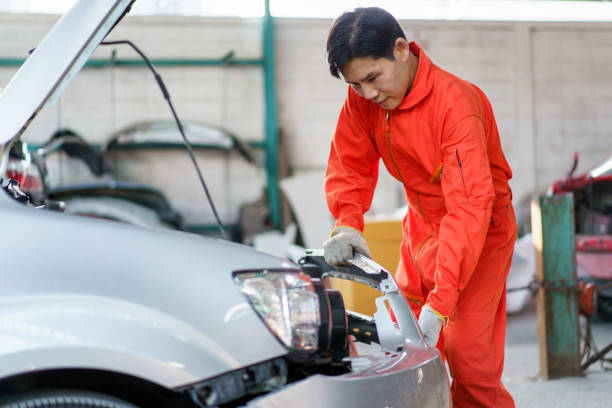 technicien asiatique réparant une voiture. - car inspector examining failure photos et images de collection