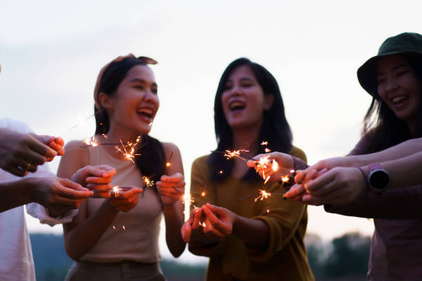 istock Group of Asian people playing sparkling firework. 1876189733