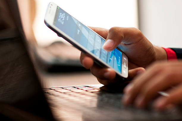 istock Businessman hand using laptop and mobile phone in office 187625854