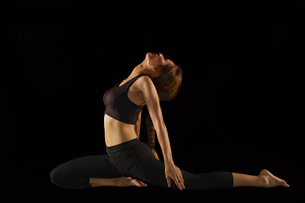 istock beautiful yoga posing on black  background 187628740