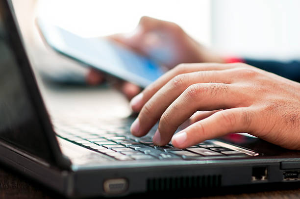 istock Businessman hand using laptop and mobile phone in office 187628846