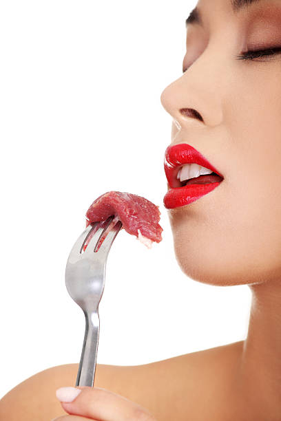 istock Young beautiful woman eating raw meat. 187629197