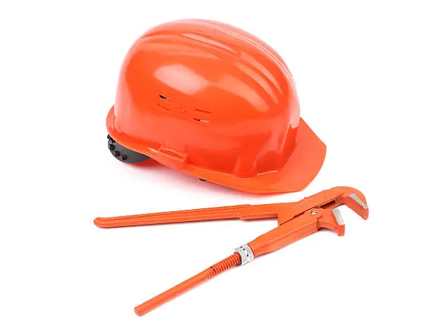 Hard hat and wrench close up. Isolated on a white backgropund.