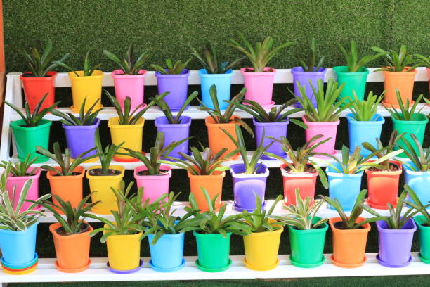 Stacks of brightly painted flower pots in a retail display.