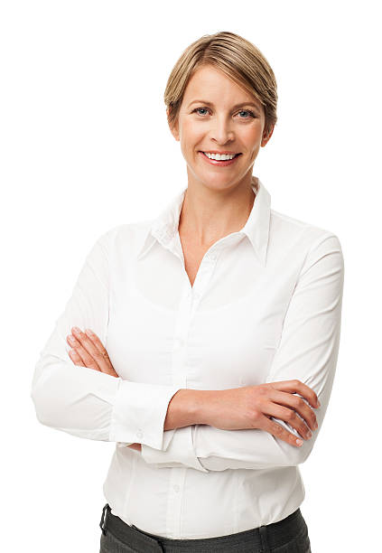 Businesswomen smiling and crossing her arms Portrait of happy mid adult businesswoman standing arms crossed against white background. Vertical shot. three quarter length stock pictures, royalty-free photos & images