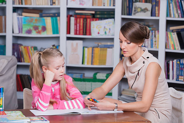 istock Child psychologist working with little girl using crayons 187644184