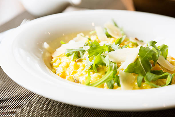 Risotto with butternut sqash and pieces of chestnut, decorated with slices of parmesan cheese and arugula