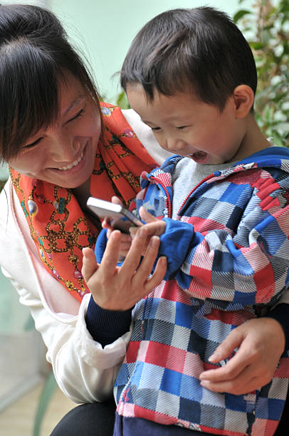 istock Boy Holding and touching on mobile phone with his mother 187647686
