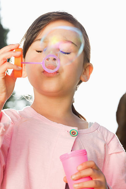 istock Girl with her eyes closed is blowing bubbles 187647703
