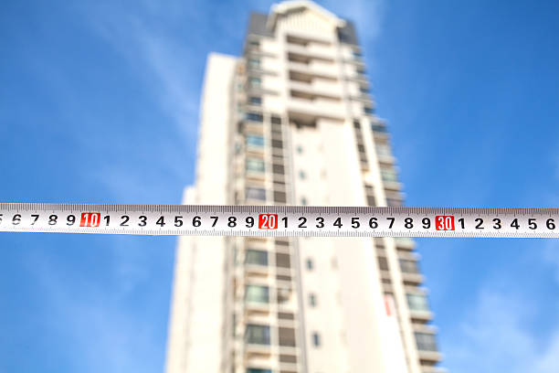 Close-up of measurement tape in front of building.
