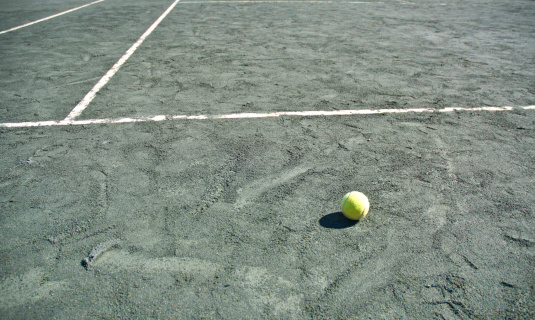 Green Clay Tennis Court With Ball And White Boundary Lines