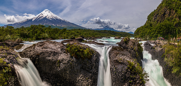 A panorama of the Petrohué Waterfalls with snow-capped Osorno Volcano seen in the background, Vicente Pérez Rosales National Park, Lake District, Chile