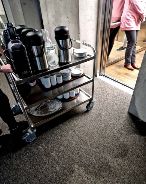 istock the serving cart delivers refreshments to the office coffee and tableware must not be missing at any corporate meeting. stainless steel lift, the door is driven by a hotel waitress 1876564209