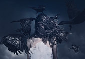 Young woman in motion with flying ravens